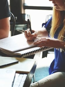 Woman writing in spiral notebook